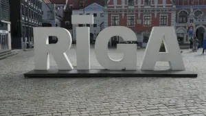 Lieli balti burti ar uzrakstu RĪGA uz vēsturiskas bruģētas ielas vecpilsētā.