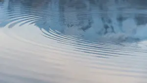 Koncentriski viļņi uz mierīgas ūdens virsmas simbolizē emociju plūdumu un pašrefleksiju.