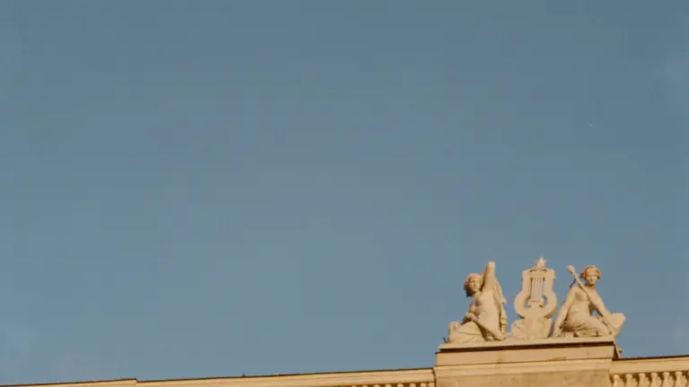 Latvijas Nacionālās operas un baleta ēkas fasādes fragments Rīgā skaidrā dienas gaismā.
