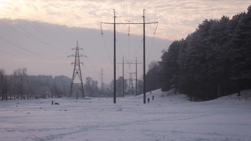 Augstsprieguma elektrības pārvades līnijas sniegotā Latvijas ainavā ziemas laikā
