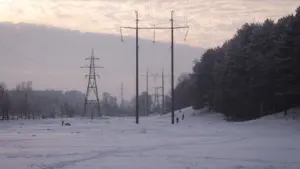 Augstsprieguma elektrības pārvades līnijas sniegotā Latvijas ainavā ziemas laikā