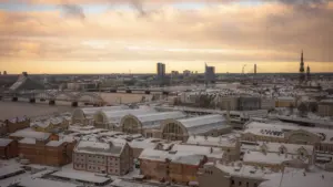 Pilsētas skats ar pirmajām sniega kārtām uz jumtiem vēlā rudens vakarā Rīgā