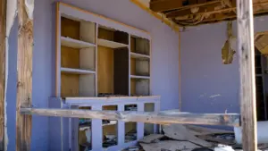 Iekštelpas ar izpostītiem plauktiem un būvgružiem, kas simbolizē nedrošību un iekšējo nemieru.